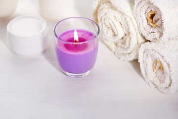 Obraz na płótnie Canvas White towels scented candle with lavender scent cream jar on white background for cosmetic procedures