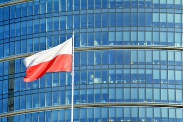  Polish flag on a pole waving, modern office building background