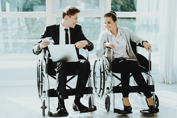 Woman and Man in Wheelchairs in Business Clothes.