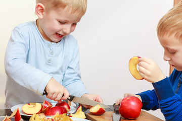 Two boys peeling apples and eating