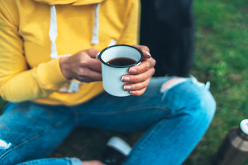 Top view girl holding in hands cup of hot tea on green grass in outdoors nature park, beautiful woman hipster enjoy drinking cup of coffee, lifestyle relax recreation meditation concept