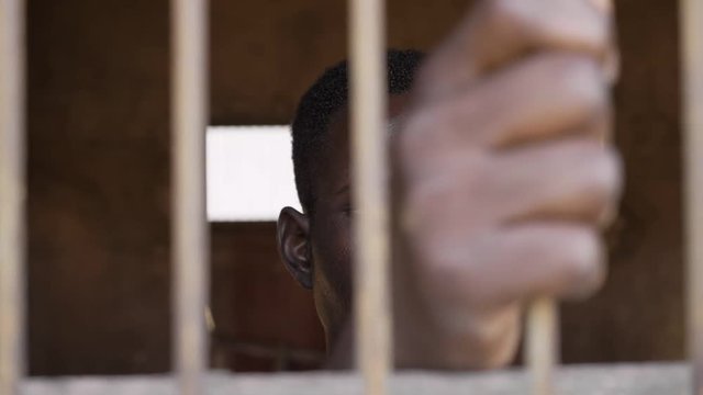 illegal immigration, prison, human rights. young african migrant in prison