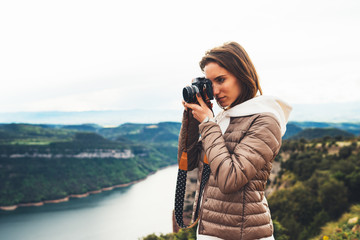photographer traveler on green top on mountain, tourist looking holding in hands digital photo...