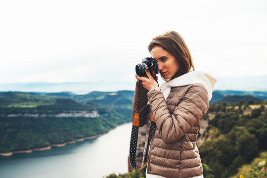 photographer traveler on green top on mountain, tourist looking holding in hands digital photo camera, hiker taking click photography, nature panoramic landscape in trip, relax holiday hobby concept