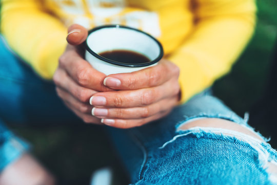 girl holding in hands cup of hot tea on yellow backgroung in outdoors nature park, beautiful woman hipster enjoy drinking cup of coffee closeup, lifestyle relax recreation meditation concept