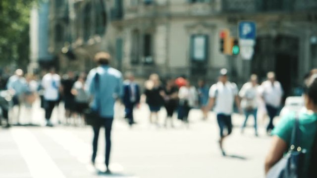 Rear view of people - slow motion defocused view city atmosphere with adults and seniors people crossing busy intersection in central Barcelona crossroads passage slowmotion
