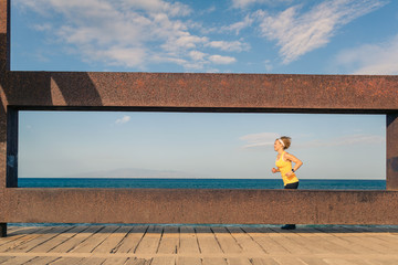 Young woman running in mountains on sunny summer day