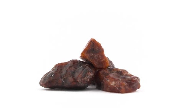 Three big Kala namak salt crystals. Brown color. Rotating. Isolated on the white background. Close up. Macro.