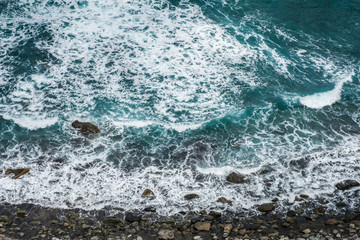 ocean coast aerial, pebble stone beach and waves