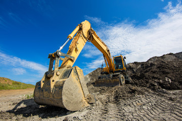 Excavator bucket on clay mining site. Wide angle