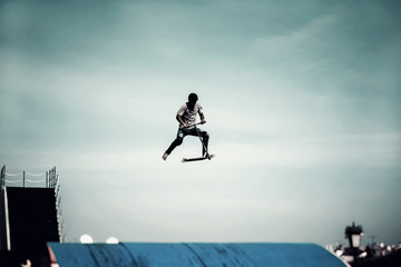 Extreme sport, contrast silhouette of young man, young man doing jump with scooter on background of...
