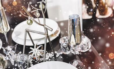 Christmas table place setting with christmas pine branches, cones, decorations with blurred, sparking, glowing. Happy New Year
