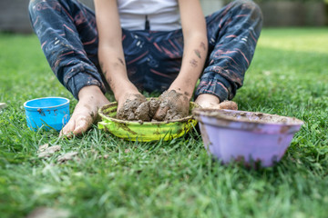 Toddler child playing with mud