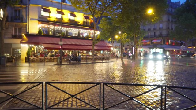 Car traffic driving through rain on an urban street in Paris France