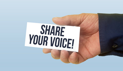 Man holding white business card with text share your voice