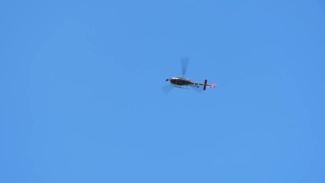 Helicopter with cine camera gimbal passing above building
