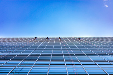 Four Window Washers Cleaning on the side of a skyscraper looking up