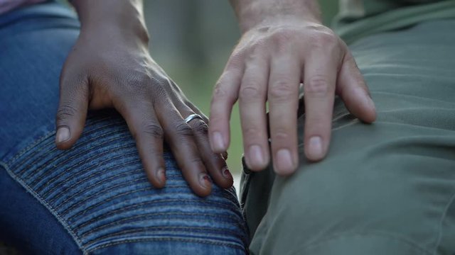 interracial love and passion - hand of a white man and a black woman touching 