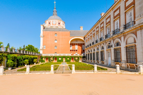 Cute and small garden between a church and a palatial building in Aranjuez, Spain. Horizontal photo.