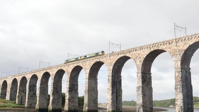 Short green train crossing River Tweed on the historic Royal Borders Bridge built in 1850 for railroad traffic across the river at Berwick-upon-Tweed, Northumberland, England