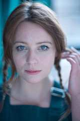 Portrait of white skin ginger girl with blue eyes with braids