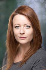 Fototapeta premium Portrait of white skin ginger girl with blue eyes with dark grey t shirt