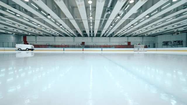 Resurfacing machine cleaning ice of hockey rink