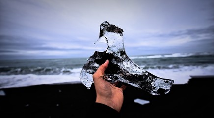 Holding up a piece of glacial ice in Iceland as the glacier shrinks over time at Jokulsarlon, Iceland