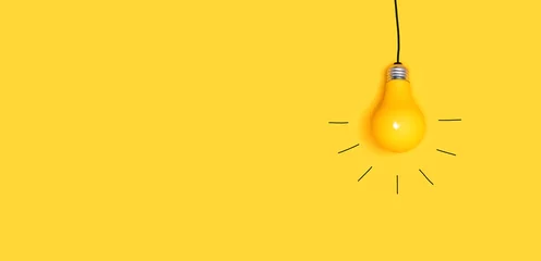 Eine hängende Glühbirne auf gelbem Hintergrund © Tierney