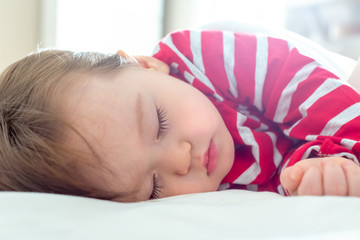 Toddler boy sleeping in his house around Christmas time