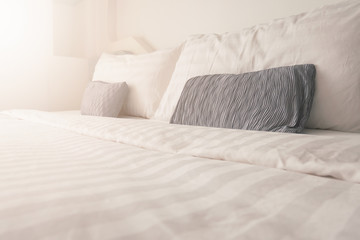 Bedding in bedroom with sunrise effect,clean white bedding sheet and pillows in beauty room interior