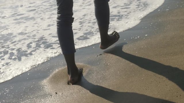 bare feet of a black man walking on the shore - nature, freedom, wildness