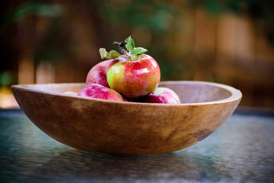 Organic apples in a rustic wooden bowl