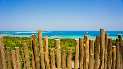 a weathered wood stick fence with breat taking beautiful blue sea landscape