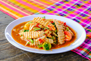 Som Tam Vietnamese Pork Sausage (Spicy Papaya Salad) with salted crab, on wooden table ( Thai food)