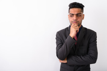 Young Indian businessman wearing suit against white background