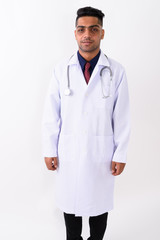 Young Indian man doctor against white background