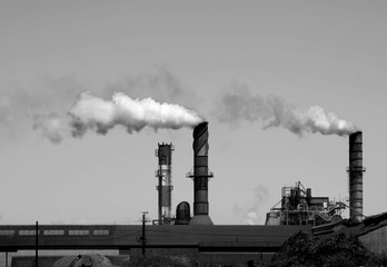 Industrial Smokestack spewing pollutants, in monochrome