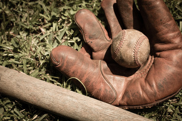 Old, Well-Used Baseball, Glove and Bat in Grass