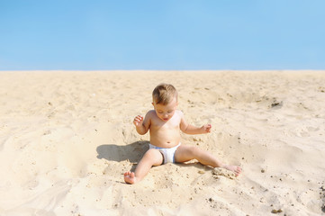 Fototapeta na wymiar Adorable little boy on the beach at warm summer day