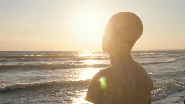 Thoughtful young african man contemplating the sea at sunset,thinking Africa