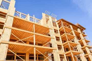 Obraz premium Six storey frame building under construction on blue sky background