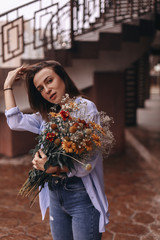 Fototapeta premium Portrait of beautiful woman which enjoying flowers. Bouquet of fields flowers