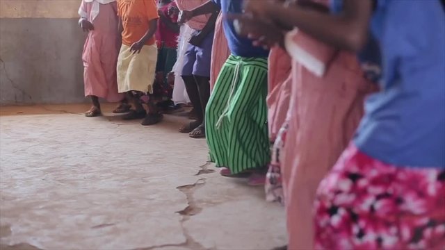 Close-up view of jumping children legs, feet. African boys and girls dancing.