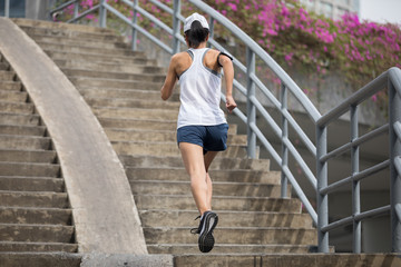 Obraz premium Young woman runner sportswoman running up city stairs