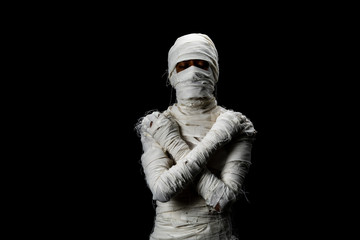 Studio shot portrait  of young man in costume  dressed as a halloween  cosplay of scary mummy pose like close eye and cross his arm acting standing on isolated black background. - obrazy, fototapety, plakaty