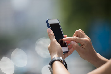 Hands using smartphone in modern city