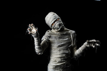 Studio shot portrait  of young man in costume  dressed as a halloween  cosplay of scary mummy pose like a clamber acting on isolated black background - obrazy, fototapety, plakaty