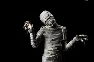 Fototapeten Studio shot portrait  of young man in costume  dressed as a halloween  cosplay of scary mummy pose like a clamber acting on isolated black background © Bangkok Click Studio