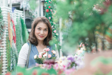 Beautiful Asian woman is buying flowers happily from the flower shop. Available in a variety of colors